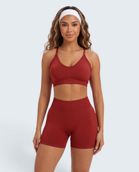 Modelo veste conjunto desportivo vermelho VD Beyond Limits com top e calções seamless de cintura subida e alta fixação
