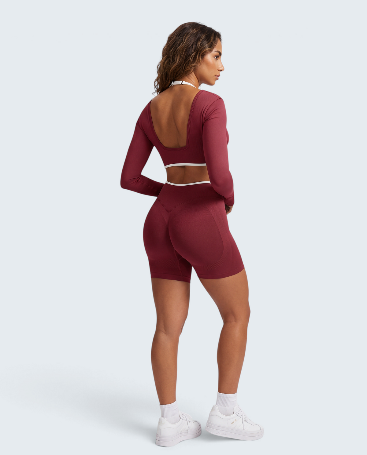 Conjunto seamless VD Beyond Limits bordeaux com top de manga comprida e calções de cintura alta em modelo desportivo