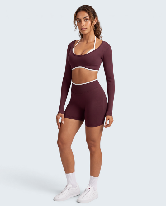 Modelo veste conjunto desportivo seamless bordô da VD Beyond Limits com top de manga comprida e calções de cintura alta