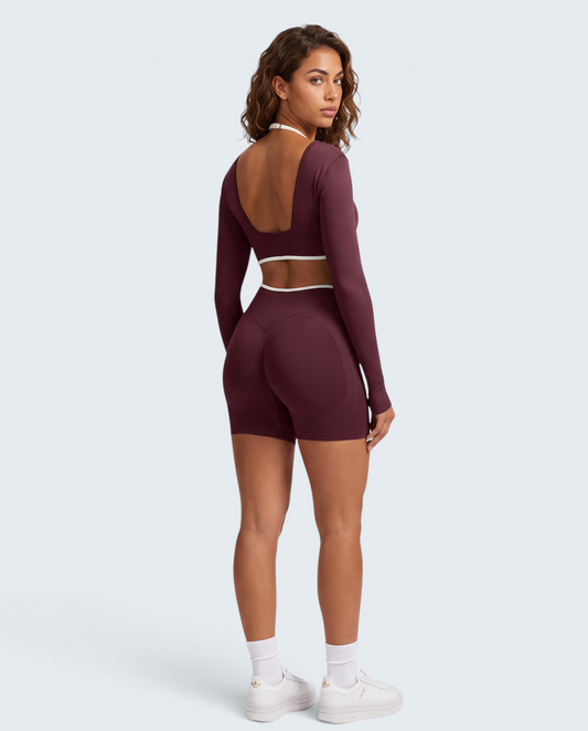 Modelo veste conjunto seamless VD Beyond Limits bordeaux com top de manga comprida e calções de cintura alta