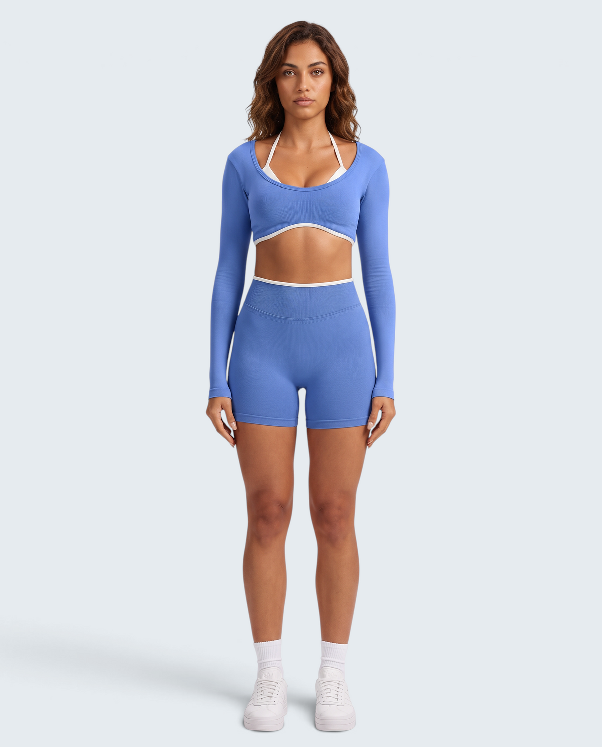 Modelo veste conjunto seamless azul VD Beyond Limits composto por top de manga comprida e calções de cintura alta.