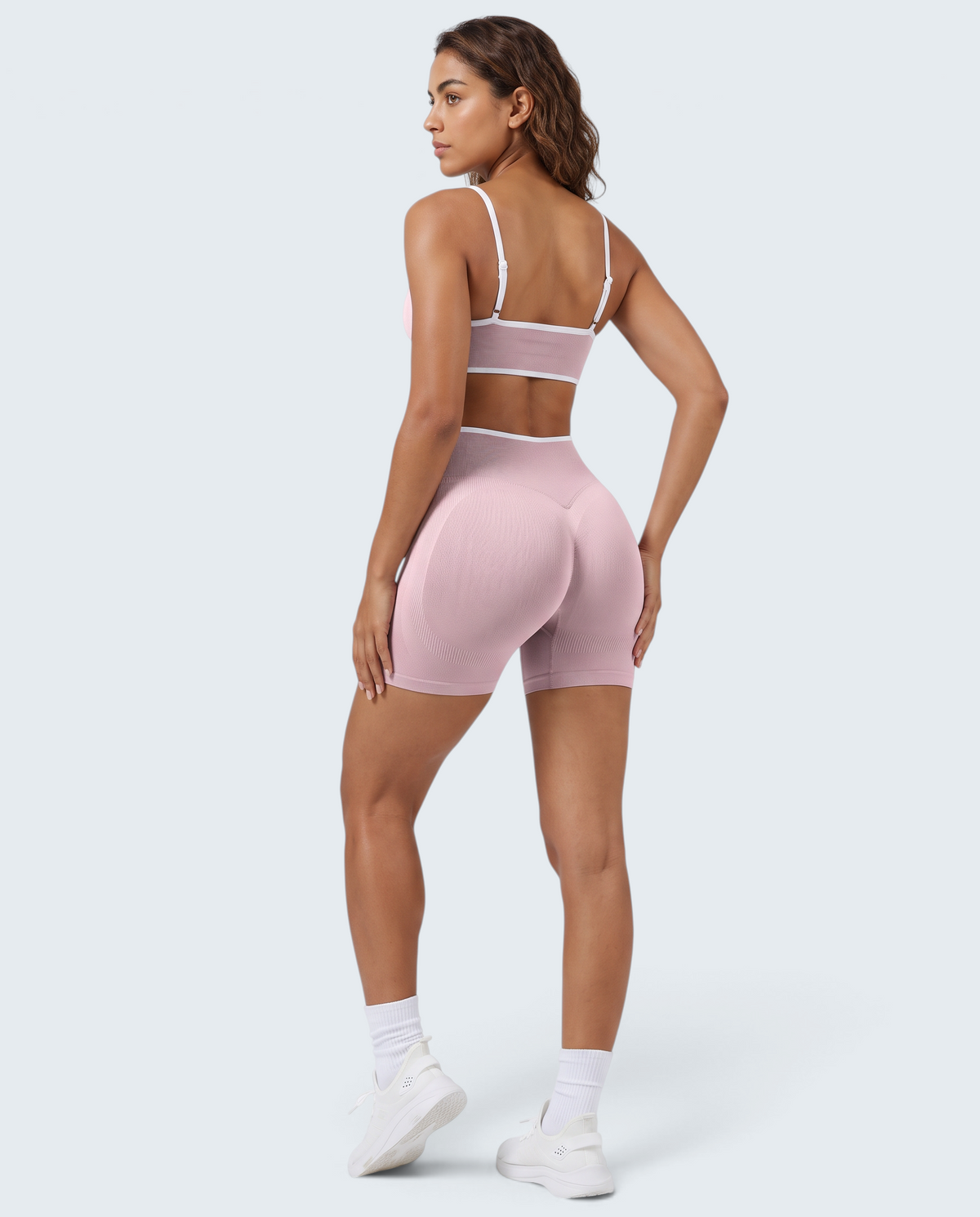 Modelo veste conjunto seamless canelado rosa VD Beyond Limits com top e calções de desporto de cintura alta