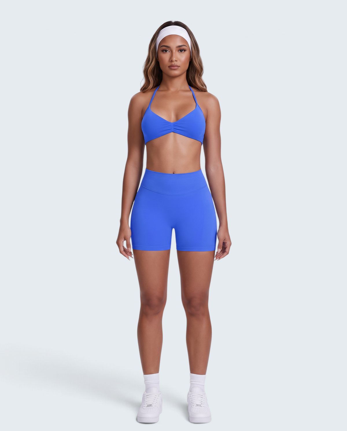 Modelo veste conjunto desportivo azul VD Beyond Limits com top halter e calções de cintura alta em tecido seamless.