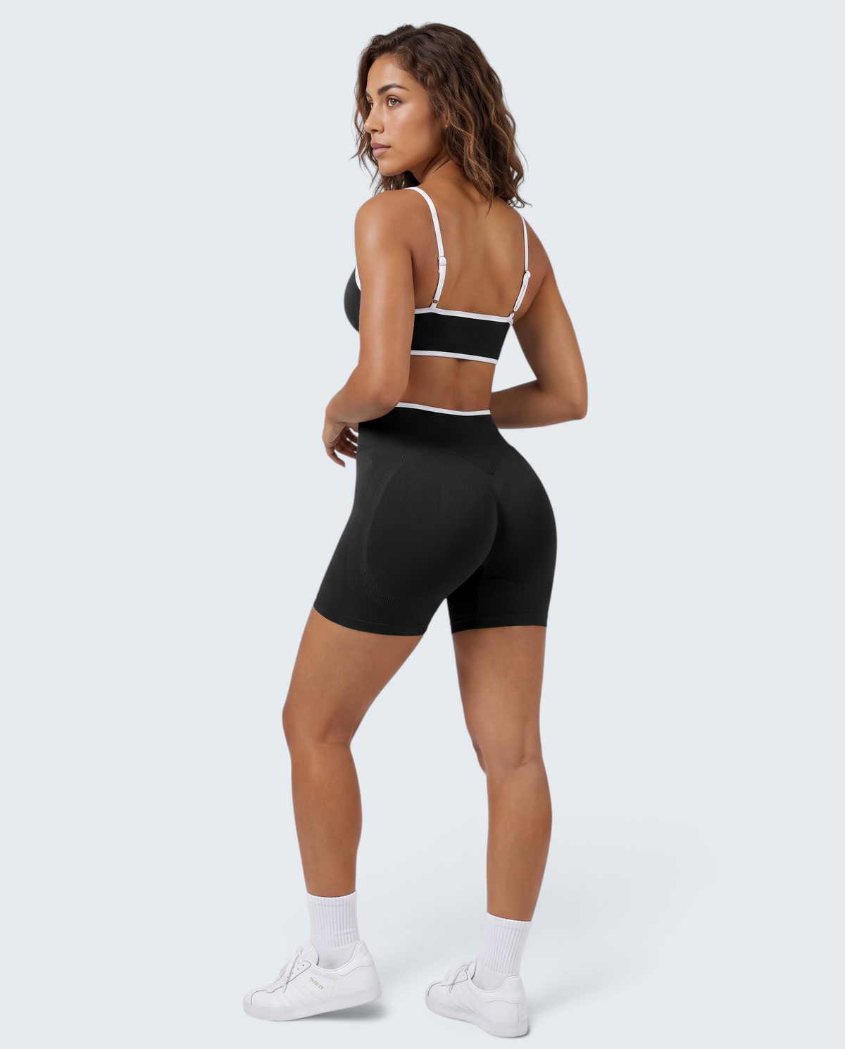 Modelo veste conjunto seamless canelado preto VD Beyond Limits com top desportivo e calções de cintura alta