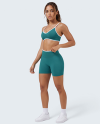 Modelo veste conjunto desportivo VD Beyond Limits verde-petróleo com top e calções seamless de cintura alta