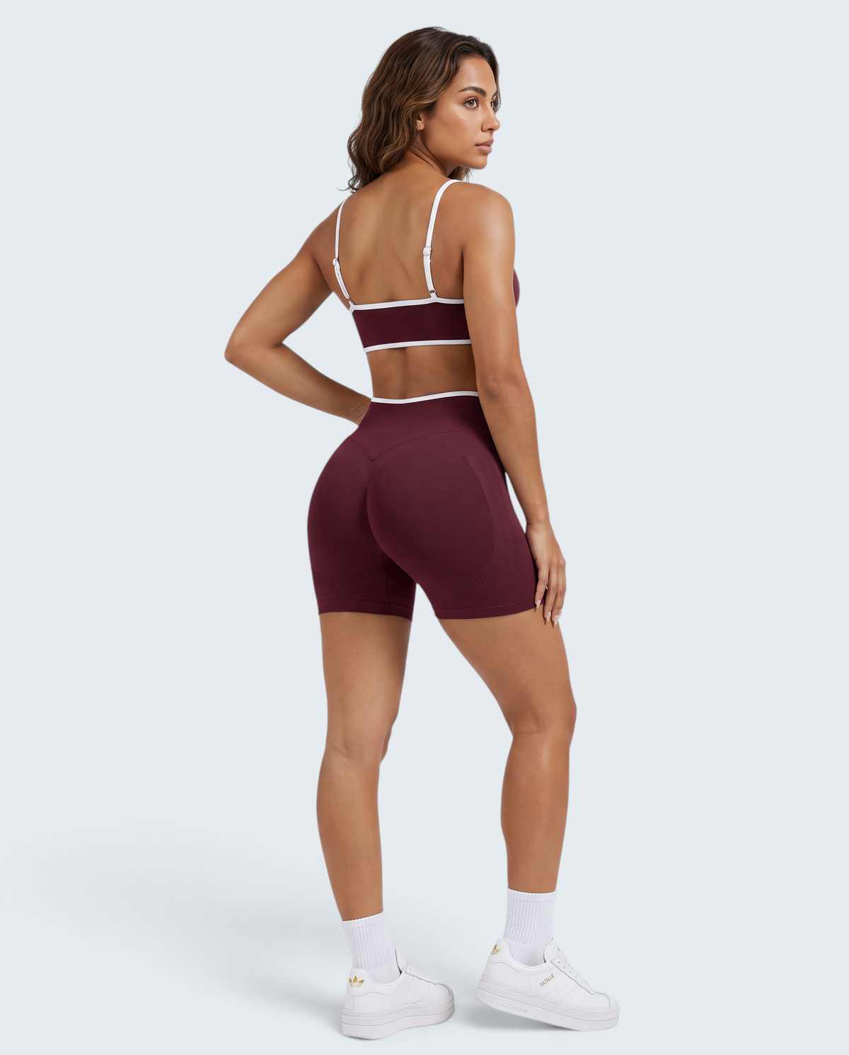 Modelo veste conjunto seamless canelado bordô VD Beyond Limits com top cropped e calções desportivos de cintura alta.