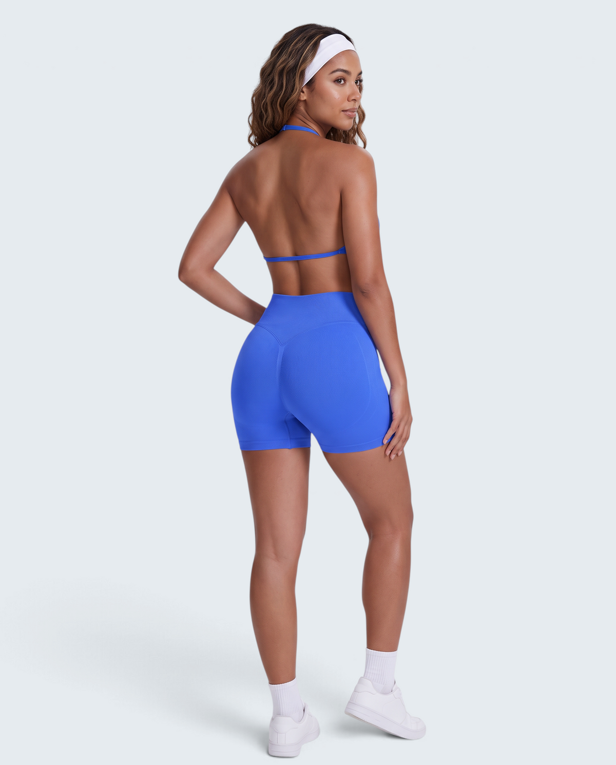Modelo veste conjunto desportivo azul VD Beyond Limits com top halter e calções seamless de cintura alta