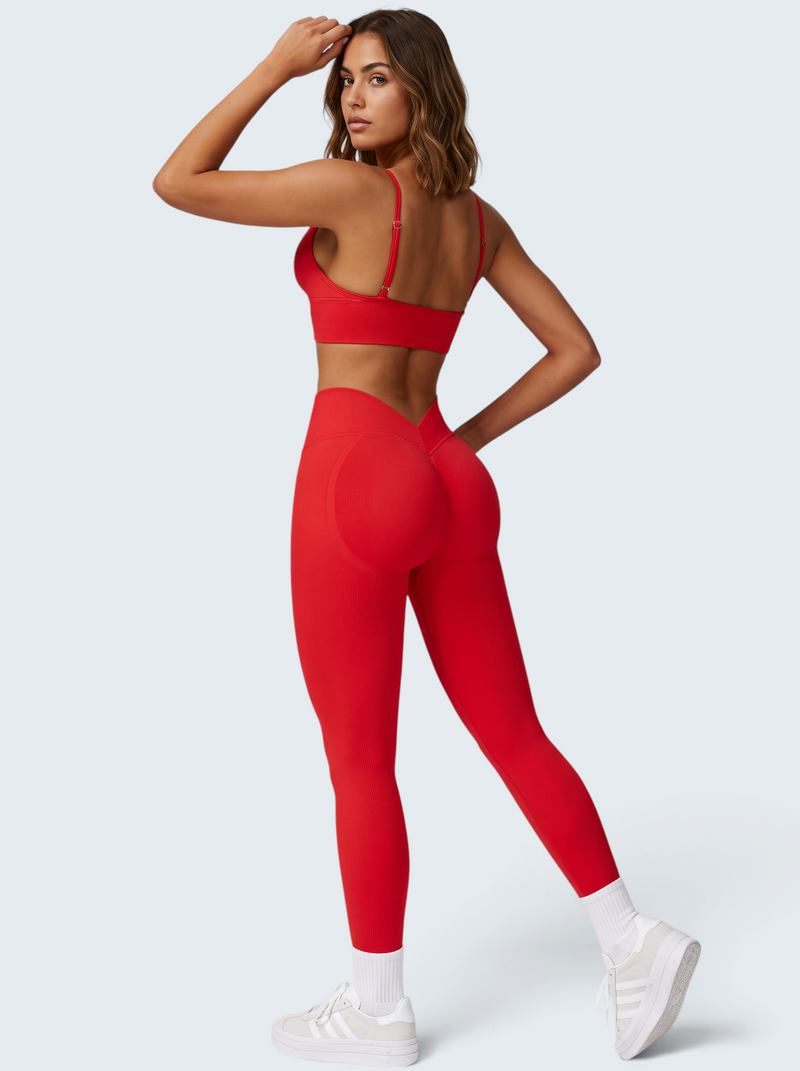 Modelo veste conjunto activewear vermelho VD Beyond Limits com bra desportivo e leggings seamless de cintura alta.