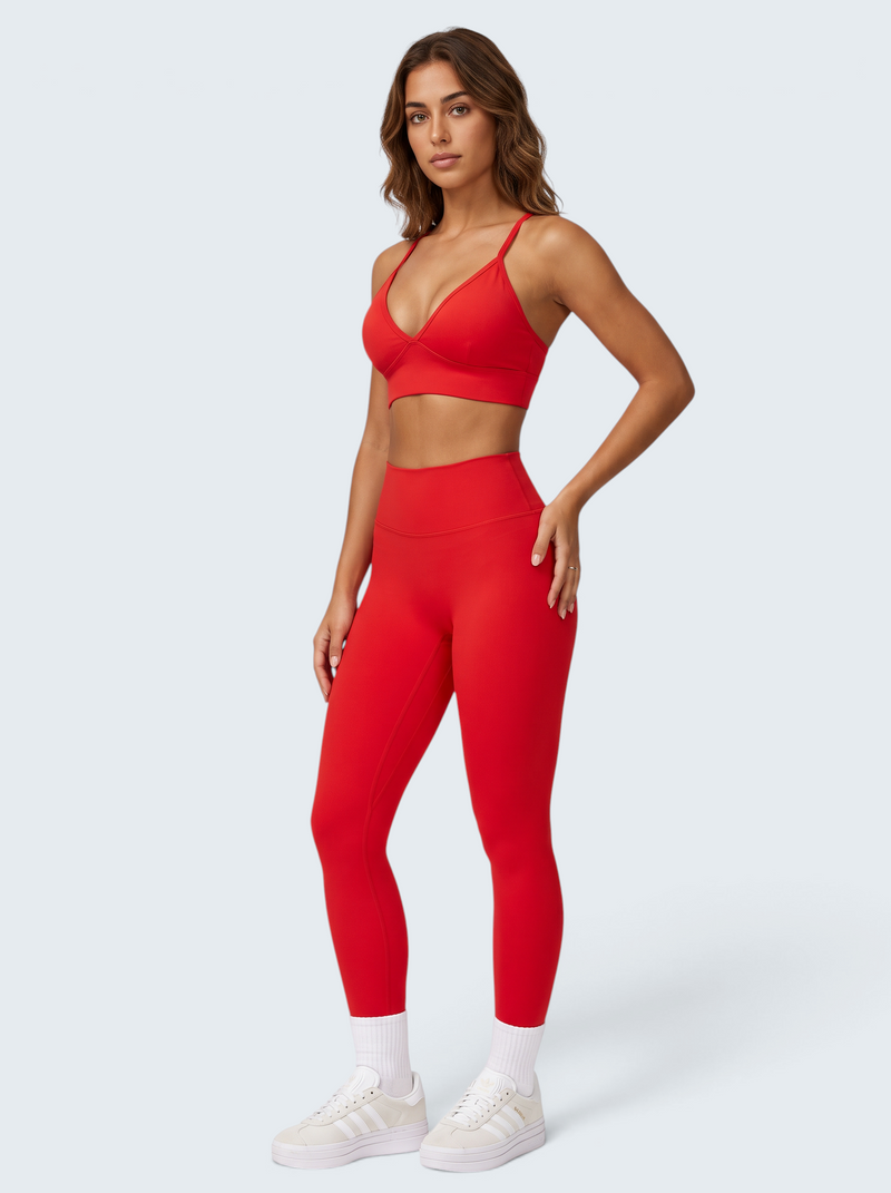 Modelo veste conjunto activewear seamless vermelho VD Beyond Limits com bra desportivo e leggings de cintura alta.
