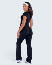 Modelo veste conjunto desportivo preto VD Beyond Limits com t-shirt justa e calças flare de cintura alta