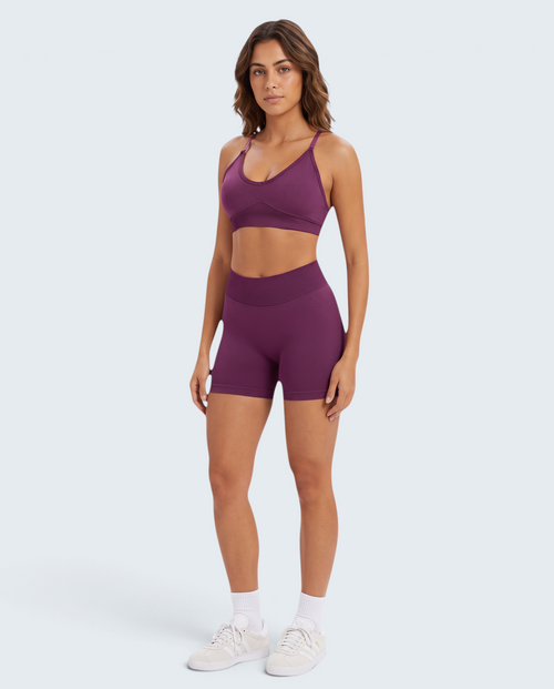 Modelo veste conjunto desportivo roxo VD Beyond Limits com top e calções seamless de cintura subida para treino.
