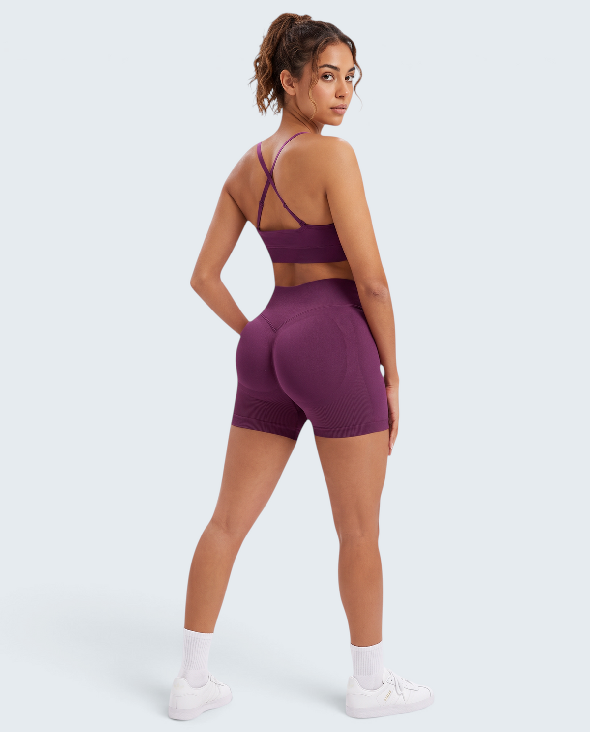 Modelo veste conjunto seamless roxo VD Beyond Limits com top de alças cruzadas e calções de cintura subida