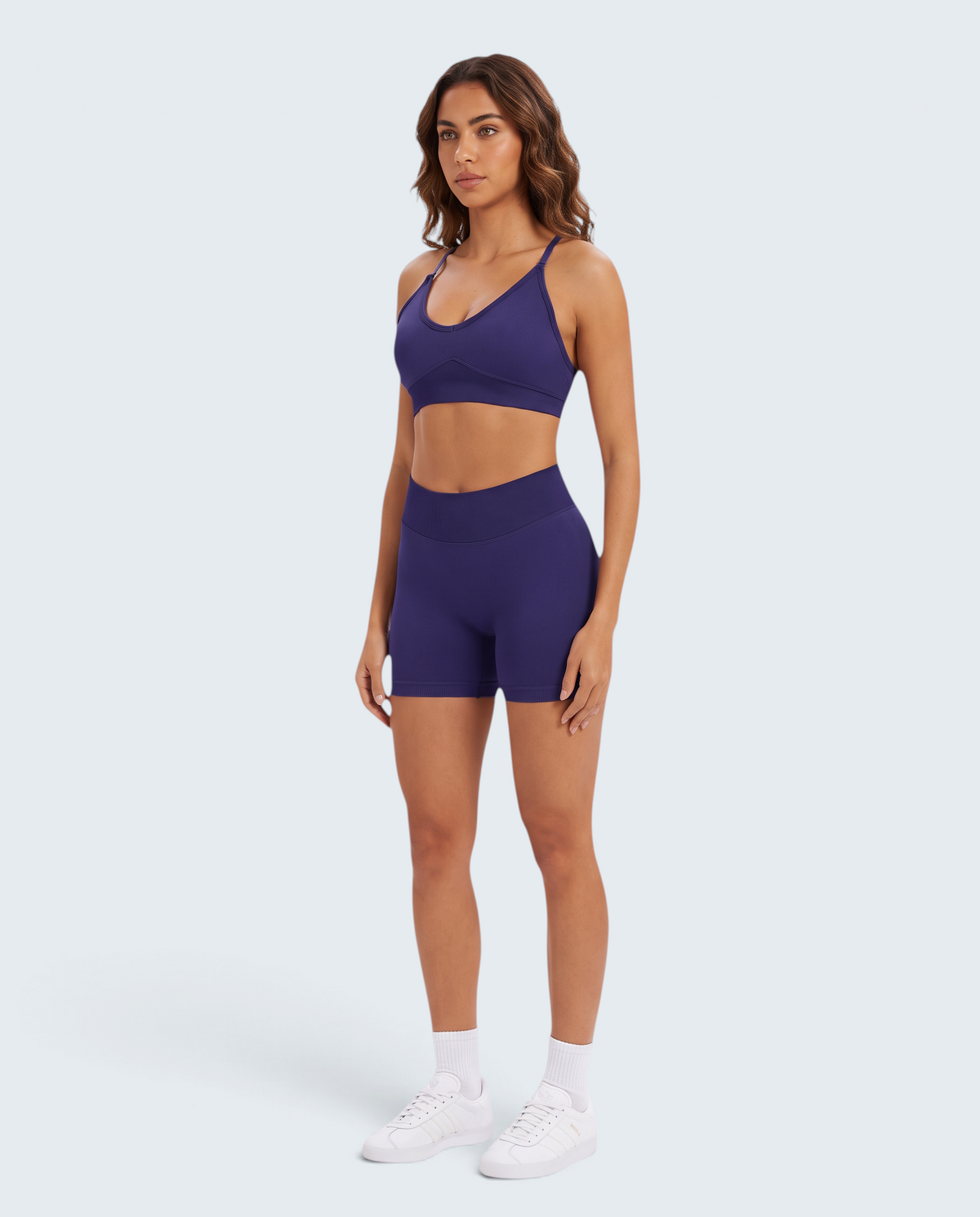 Modelo veste conjunto desportivo VD Beyond Limits roxo escuro com top e calções seamless de cintura subida
