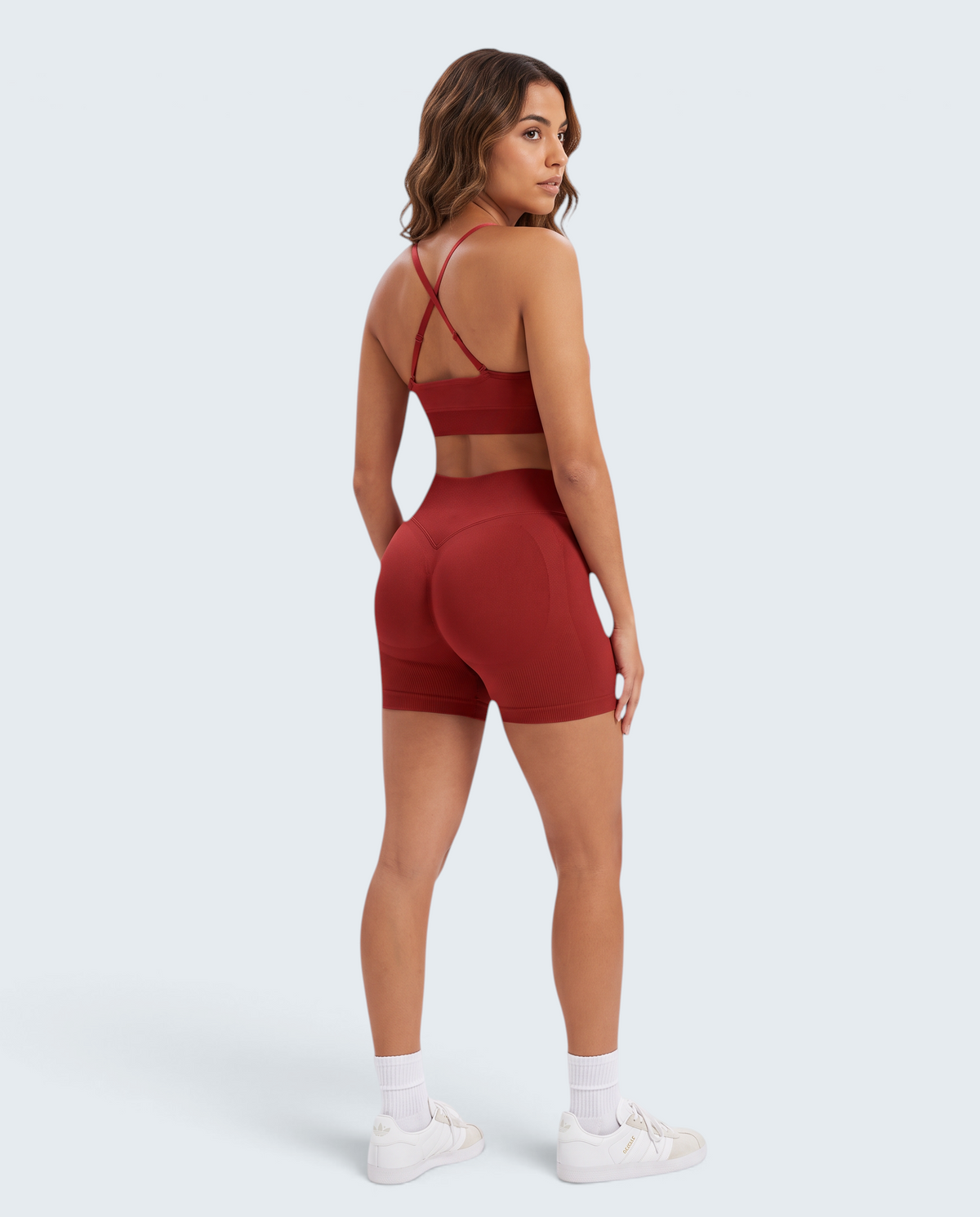 Modelo veste conjunto desportivo vermelho VD Beyond Limits com top de alças cruzadas e calções seamless de cintura alta