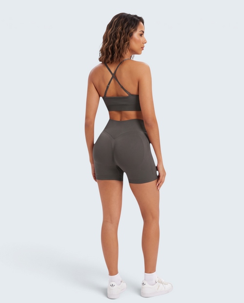 Modelo de costas veste conjunto seamless cinza VD Beyond Limits com top de alças cruzadas e calções de cintura subida