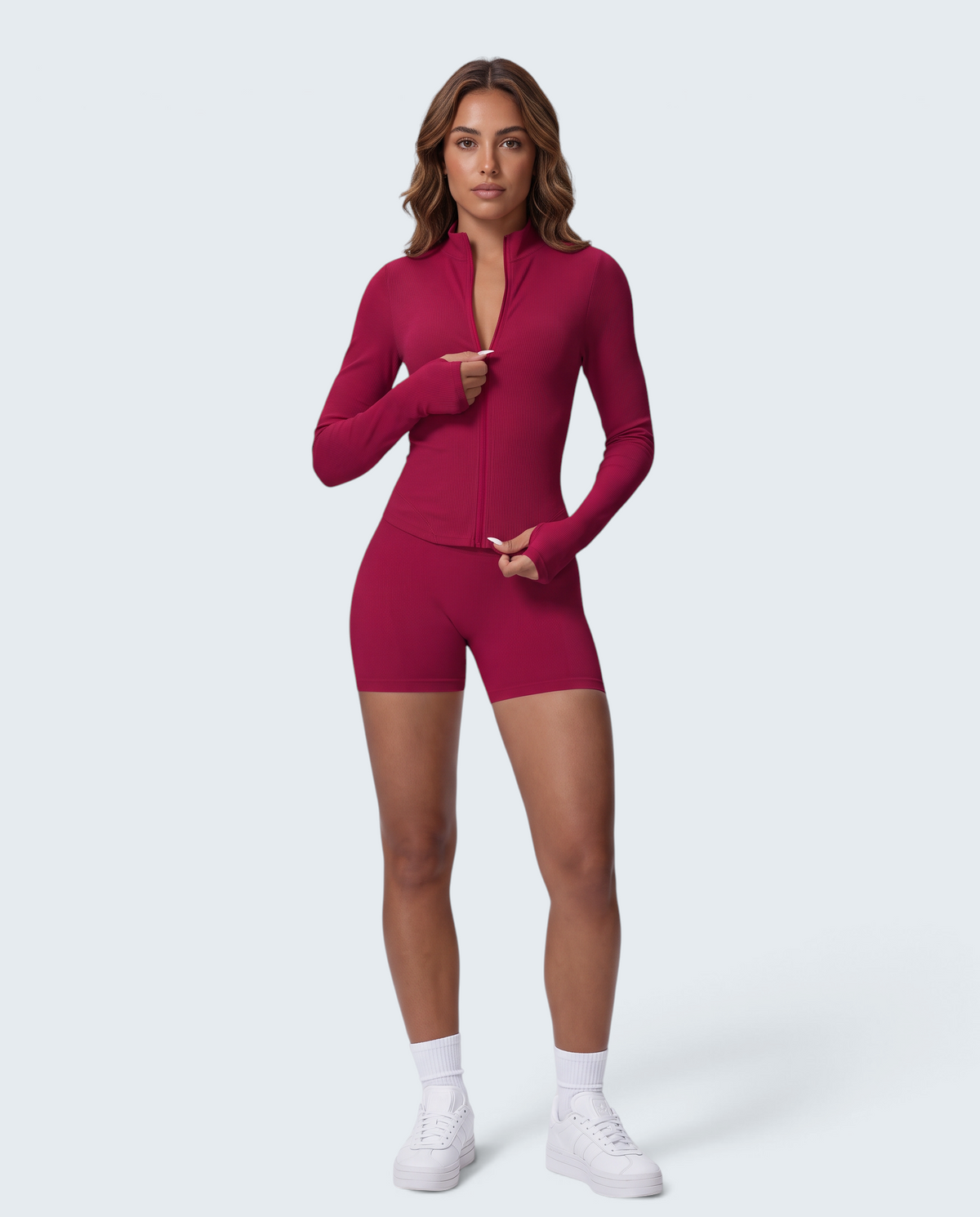 Modelo veste conjunto desportivo VD Beyond Limits vermelho com casaco de fecho e calções seamless de cintura subida.