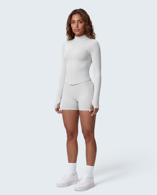 Modelo veste conjunto VD Beyond Limits Seamless Power Zip branco com casaco de fecho e calções de cintura subida