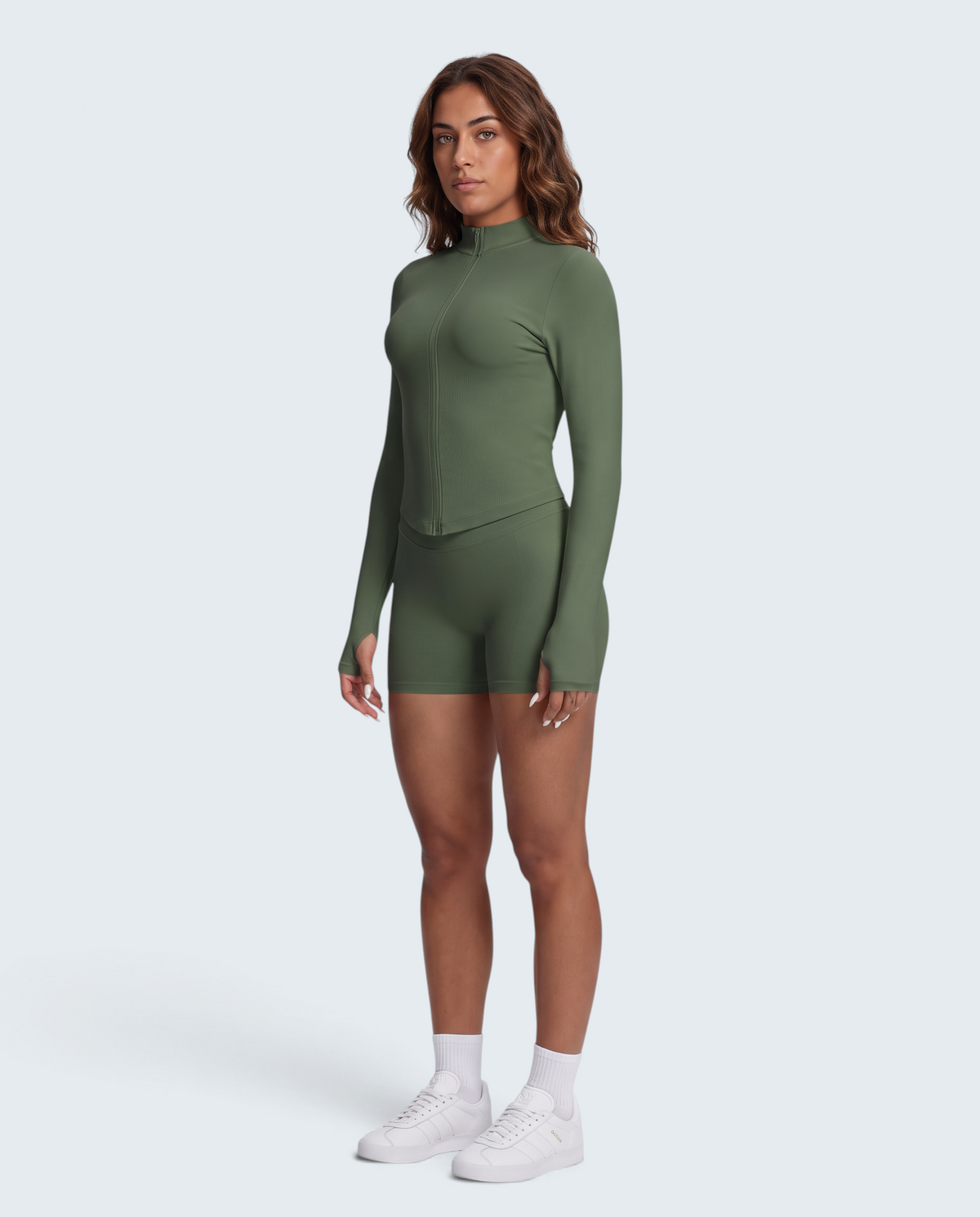 Modelo veste conjunto seamless VD Beyond Limits verde militar com casaco de fecho e calções de cintura subida