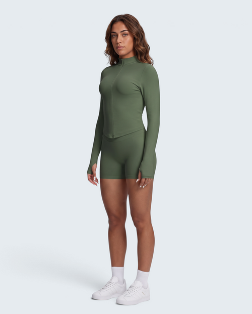 Modelo veste conjunto seamless VD Beyond Limits verde militar com casaco de fecho e calções de cintura subida