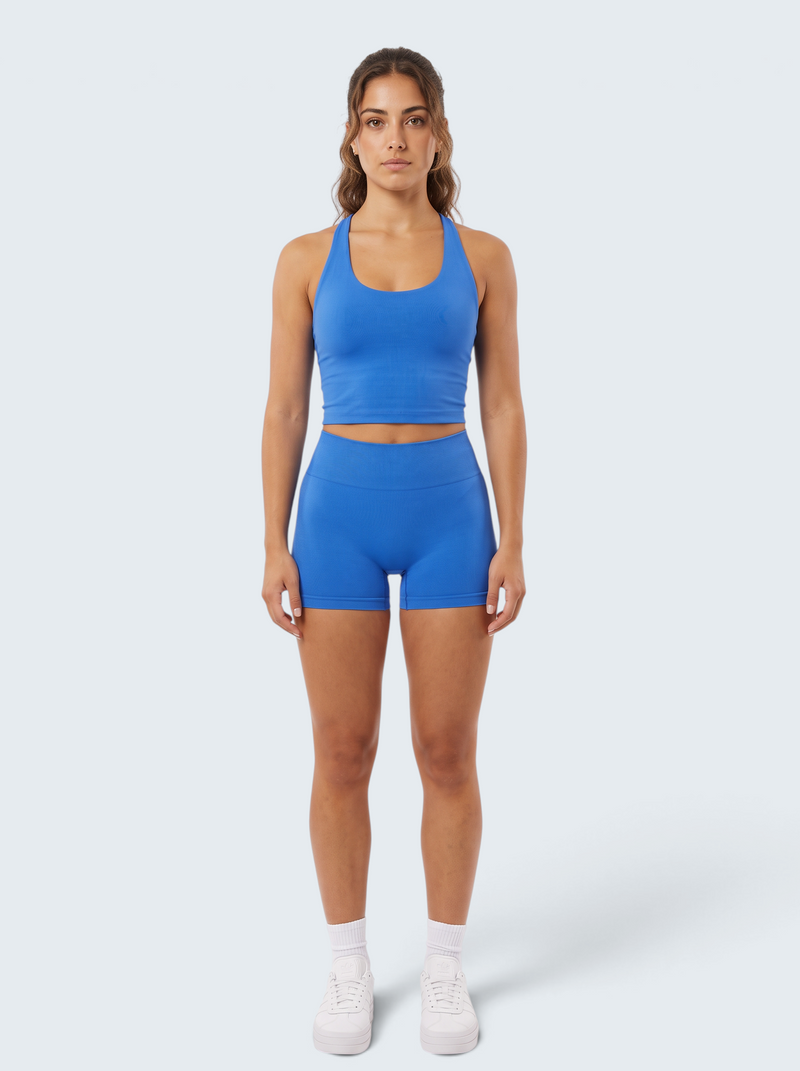 Modelo veste conjunto desportivo azul VD Beyond Limits com top cropped e calções seamless de cintura alta