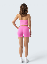 Conjunto desportivo rosa VD Beyond Limits com top sem alças e calções modeladores seamless em fundo branco
