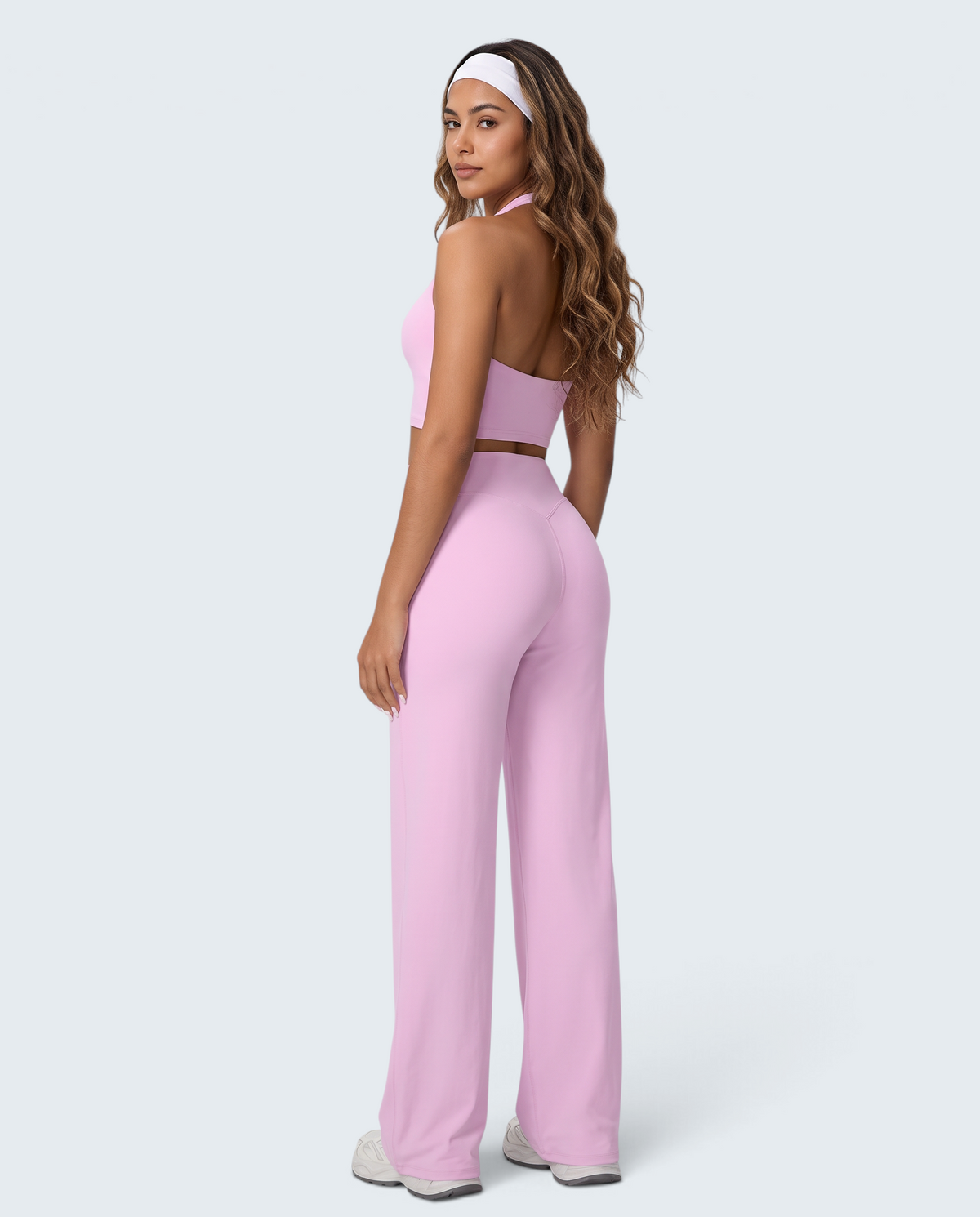 Modelo veste conjunto desportivo rosa VD Beyond Limits com top halter e calças wide leg seamless de cintura alta