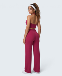 Modelo veste conjunto desportivo VD Beyond Limits cor framboesa com top halter e calças wide leg de cintura alta