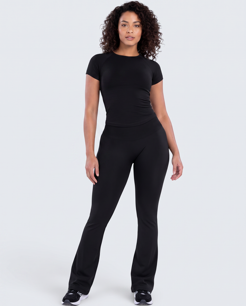 Modelo veste conjunto preto VD Beyond Limits com t-shirt justa de manga curta e calças flare de cintura alta
