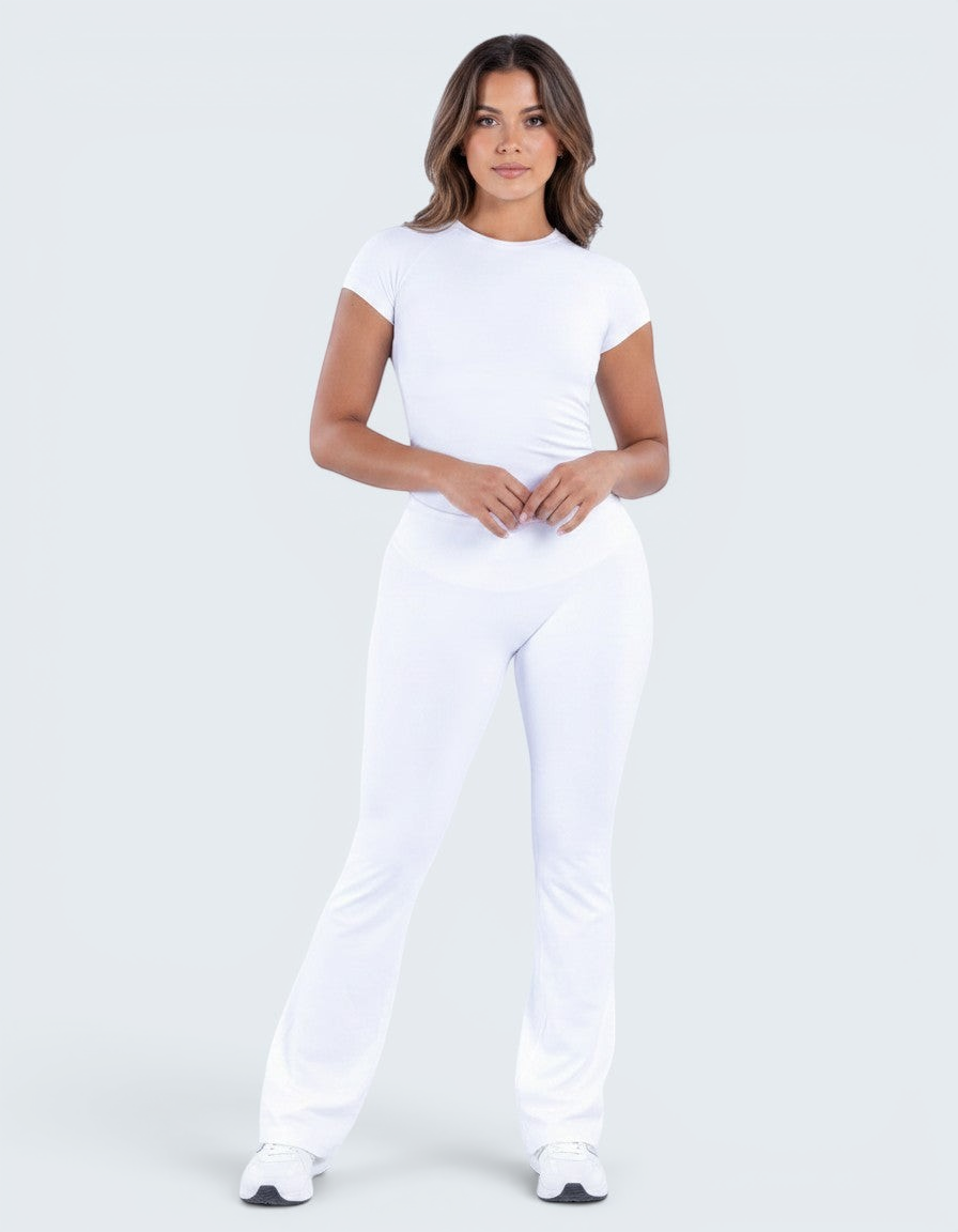Modelo veste conjunto branco VD Beyond Limits com t-shirt justa de manga curta e calças flare de cintura alta.