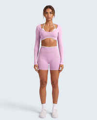 Modelo veste conjunto desportivo rosa VD Beyond Limits com top halter de manga longa e calções de cintura alta
