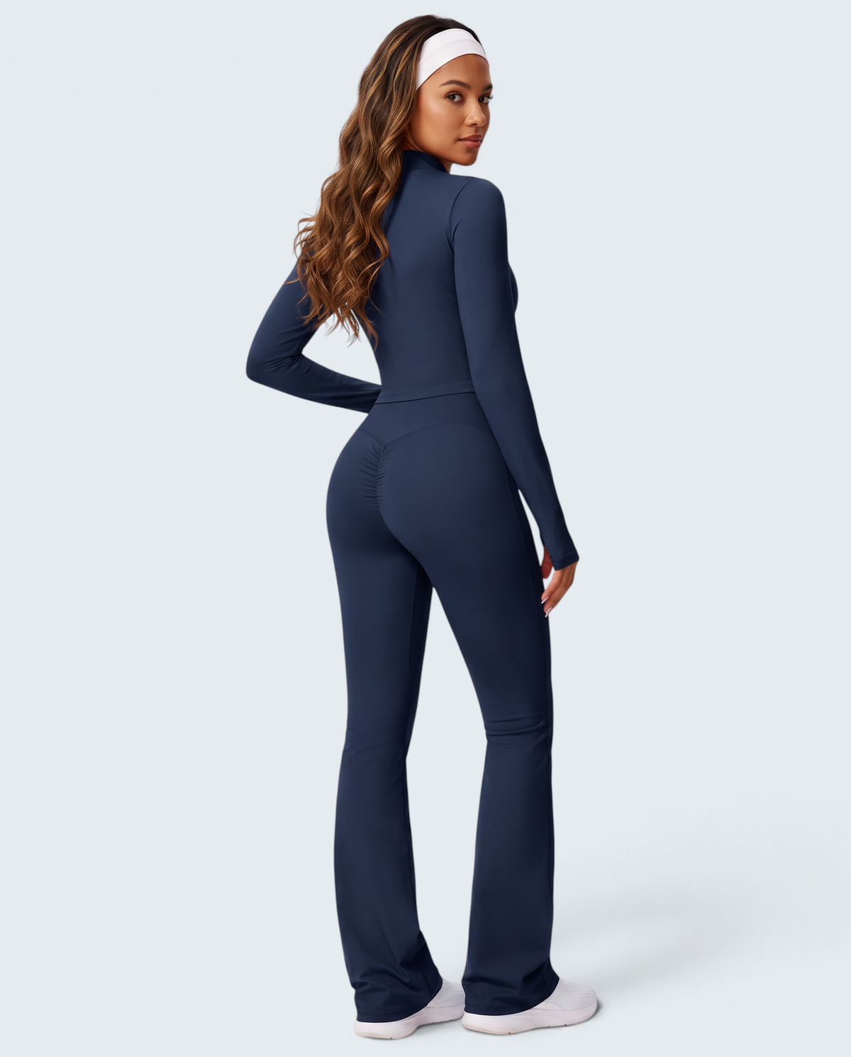 Modelo veste conjunto VD Beyond Limits de malha azul marinho com top de manga comprida e calças flare de cintura subida