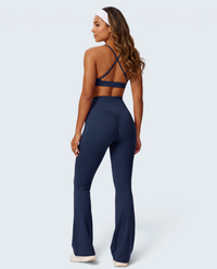 Modelo de costas usando conjunto de malha soft azul marinho da VD Beyond Limits com top de alças e calças flare.