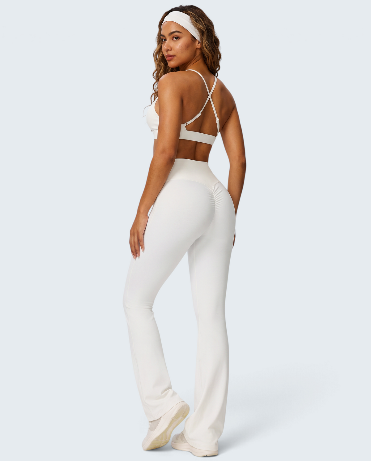 Modelo veste conjunto VD Beyond Limits branco com top de alças cruzadas e calças flare de malha macia e elástica
