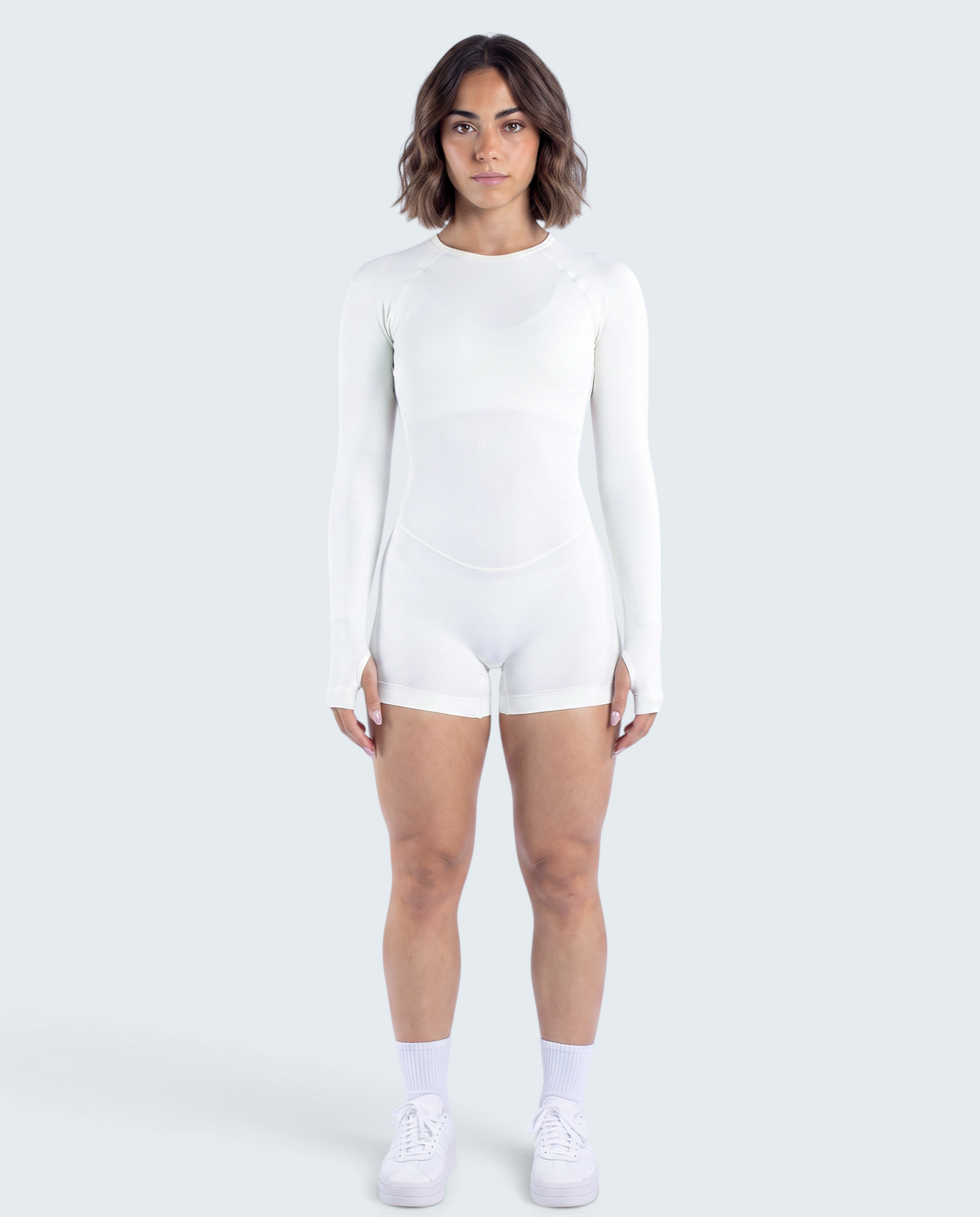 Modelo veste macacão branco seamless de manga comprida da VD Beyond Limits, ideal para yoga e treino funcional.