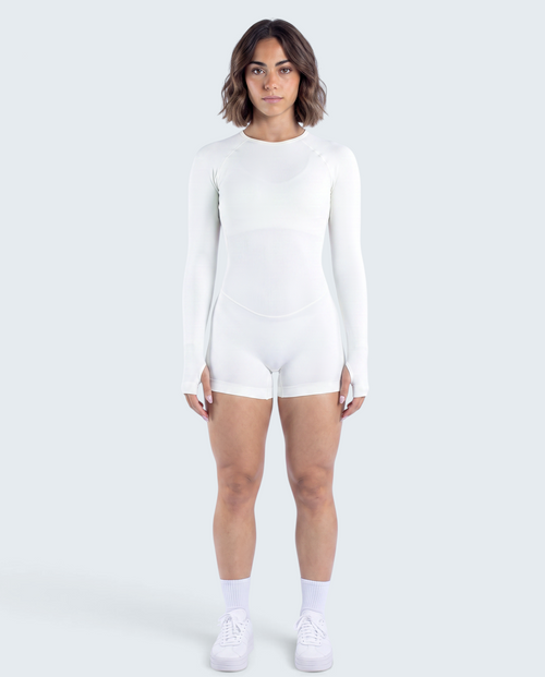 Modelo veste macacão branco seamless de manga comprida da VD Beyond Limits, ideal para yoga e treino funcional.
