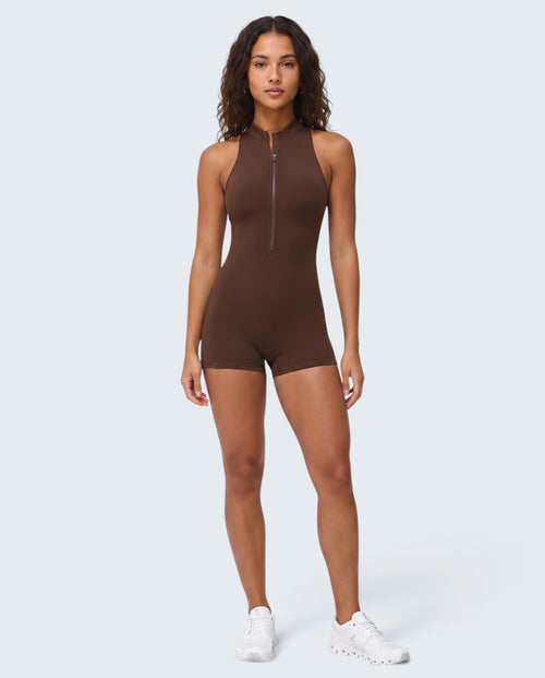 Modelo veste macacão curto castanho Seamless Sculpt da VD Beyond Limits com fecho frontal e ajuste tipo segunda pele