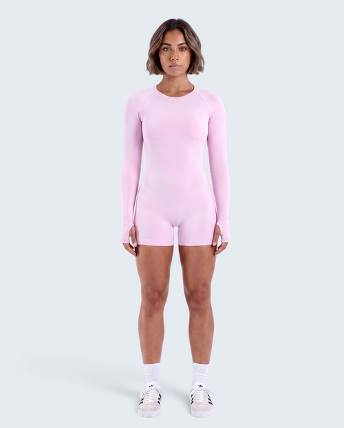 Modelo veste macacão curto rosa VD Beyond Limits seamless de manga comprida com aberturas para polegares