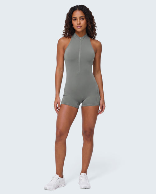 Modelo veste macacão curto cinzento VD Beyond Limits com fecho frontal, tecido seamless e ajuste de compressão.